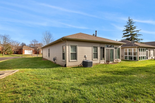 back of property with cooling unit and a yard