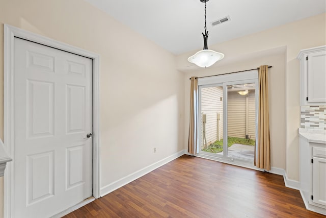 unfurnished dining area featuring dark hardwood / wood-style flooring