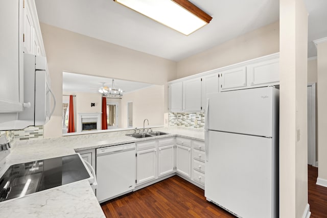 kitchen with backsplash, white cabinetry, white appliances, and sink