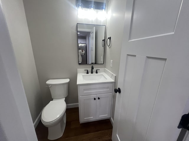 bathroom with hardwood / wood-style floors, vanity, and toilet