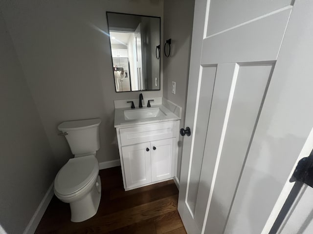 bathroom with hardwood / wood-style floors, vanity, and toilet