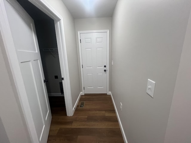 corridor with dark hardwood / wood-style flooring