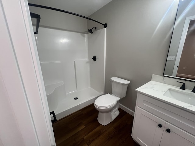 bathroom featuring vanity, hardwood / wood-style flooring, toilet, and walk in shower