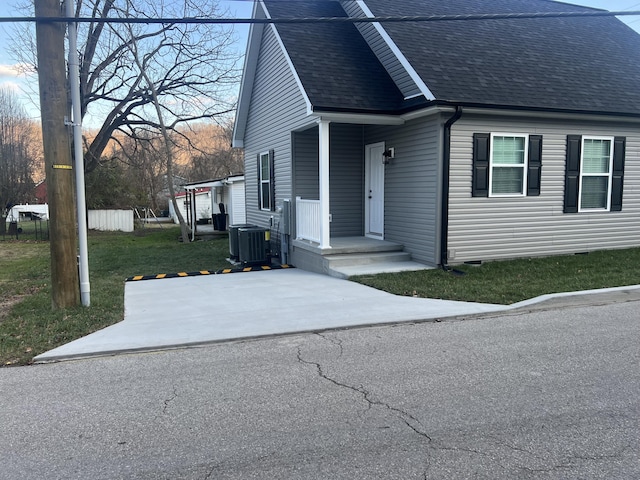 view of front of house with a front yard and central AC