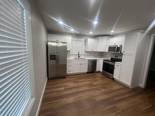 kitchen with white cabinetry, sink, dark hardwood / wood-style floors, and appliances with stainless steel finishes