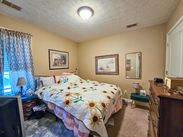 bedroom featuring light colored carpet and a textured ceiling