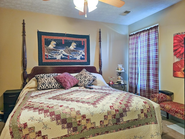 carpeted bedroom with ceiling fan and a textured ceiling