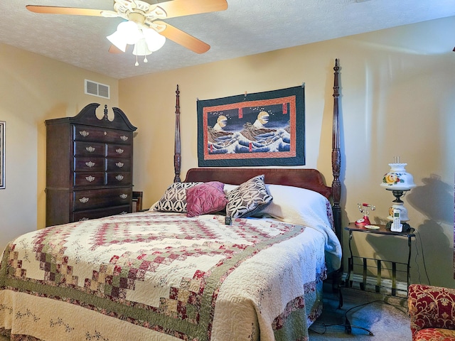 bedroom featuring ceiling fan, carpet floors, and a textured ceiling