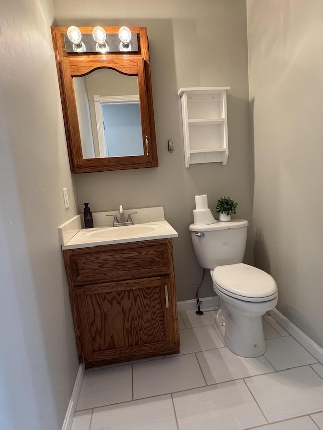 bathroom featuring tile patterned flooring, vanity, and toilet