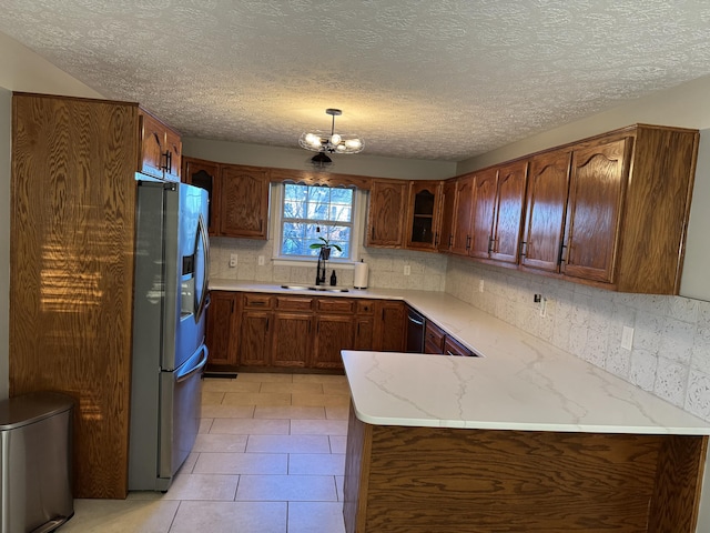 kitchen featuring sink, hanging light fixtures, an inviting chandelier, light tile patterned floors, and appliances with stainless steel finishes