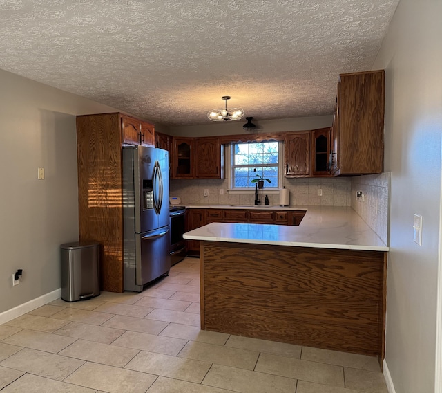 kitchen with tasteful backsplash, stainless steel fridge with ice dispenser, decorative light fixtures, and black / electric stove