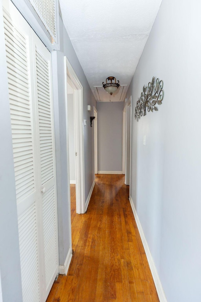 corridor with hardwood / wood-style floors