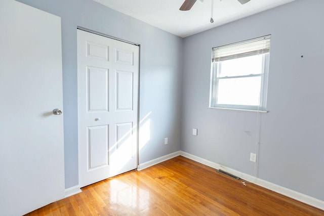 unfurnished bedroom with a closet, light hardwood / wood-style flooring, and ceiling fan