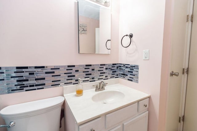 bathroom with backsplash, vanity, and toilet