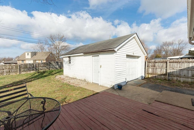 wooden terrace with a lawn, a garage, and an outdoor structure