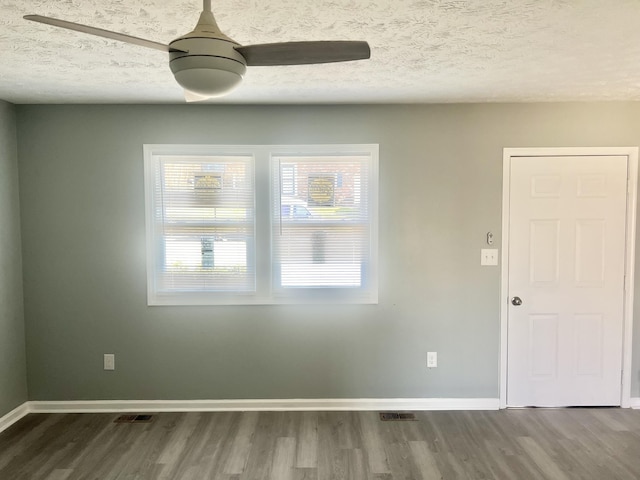 spare room with a textured ceiling, hardwood / wood-style flooring, and ceiling fan