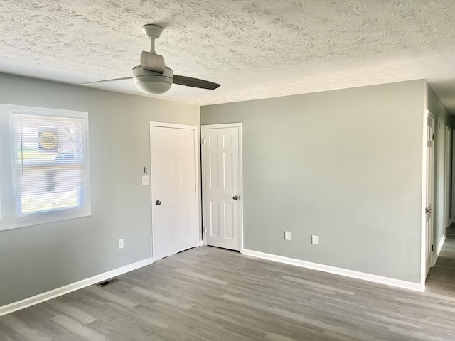 unfurnished bedroom featuring ceiling fan, wood-type flooring, and a textured ceiling