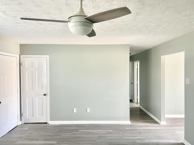 spare room with hardwood / wood-style floors, ceiling fan, and a textured ceiling