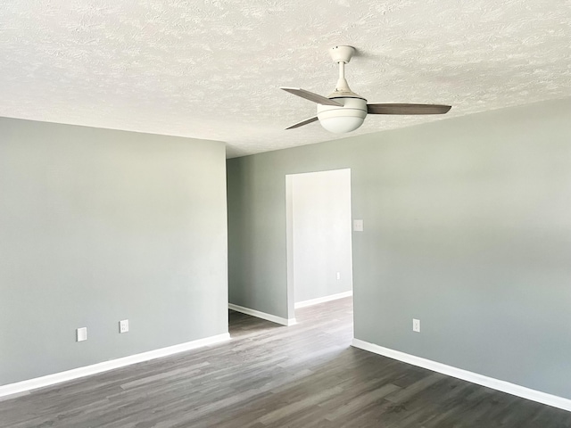 empty room with dark hardwood / wood-style floors, ceiling fan, and a textured ceiling