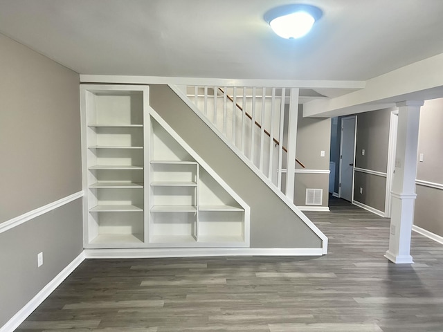 stairs with hardwood / wood-style flooring and built in shelves