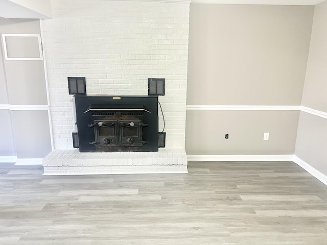 interior details with a wood stove and wood-type flooring