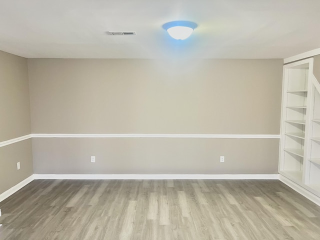 empty room with light wood-type flooring and built in features