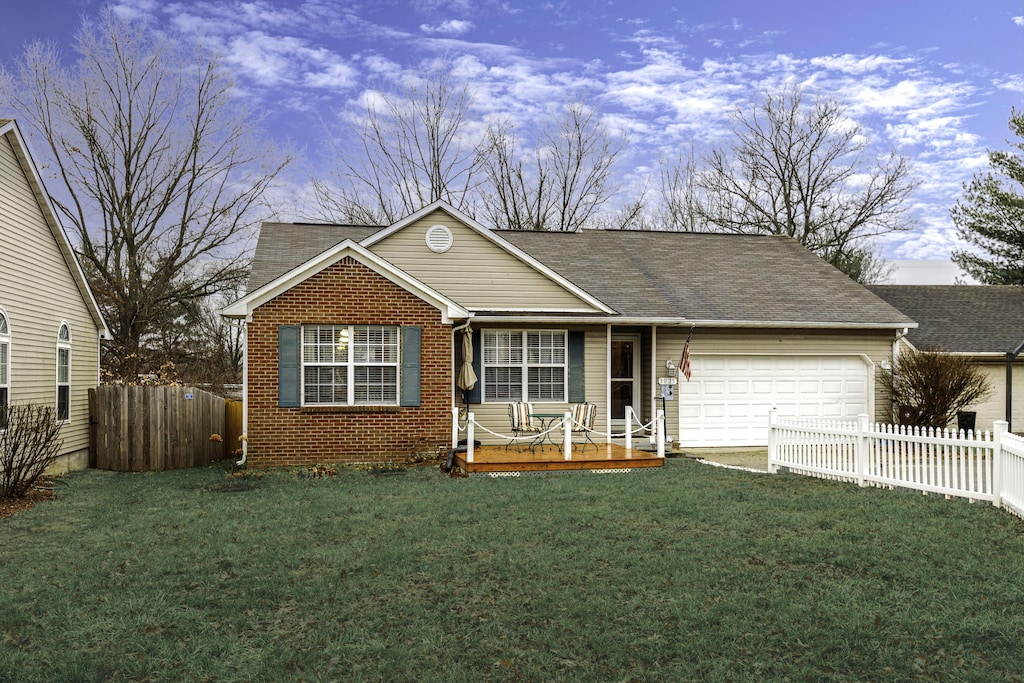 single story home featuring a yard and a garage