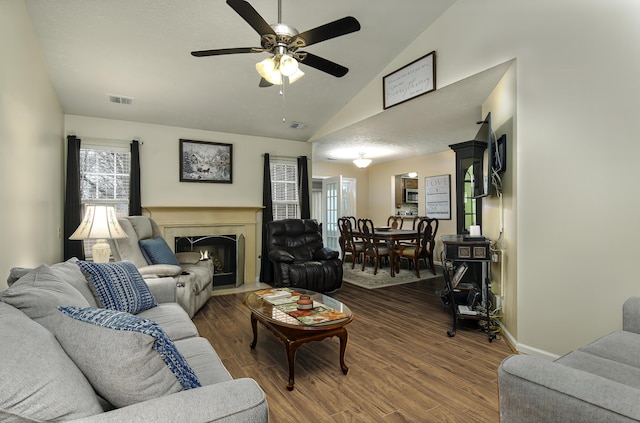 living room with ceiling fan, dark hardwood / wood-style flooring, and vaulted ceiling