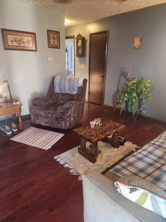 living room with dark hardwood / wood-style flooring and a textured ceiling