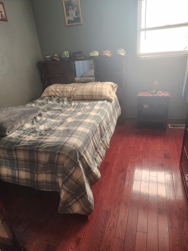 bedroom with dark wood-type flooring