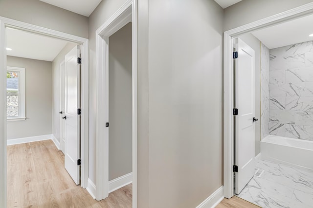 corridor with light hardwood / wood-style floors