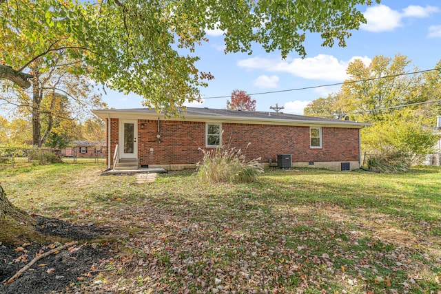 rear view of property with a lawn and central AC