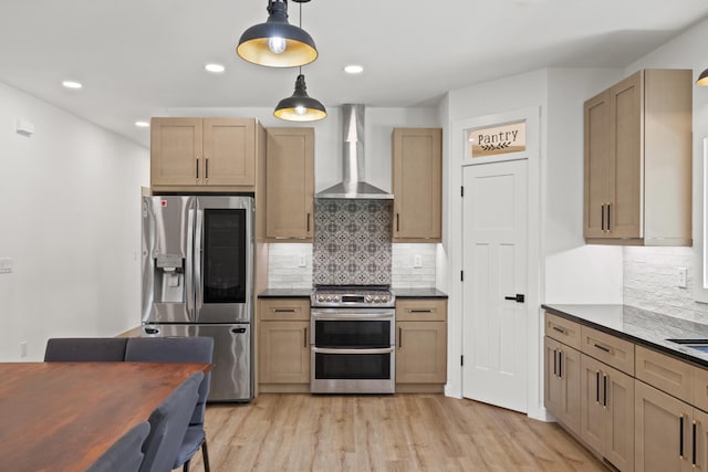 kitchen with wall chimney range hood, light hardwood / wood-style flooring, backsplash, decorative light fixtures, and appliances with stainless steel finishes