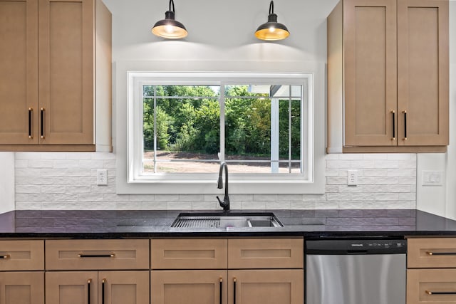 kitchen with dark stone counters, dishwasher, pendant lighting, and sink