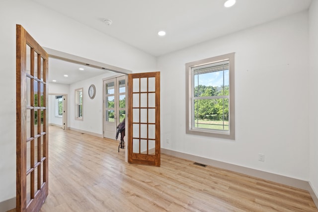 empty room with french doors and light wood-type flooring