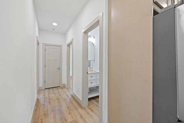 hallway with light wood-type flooring and sink