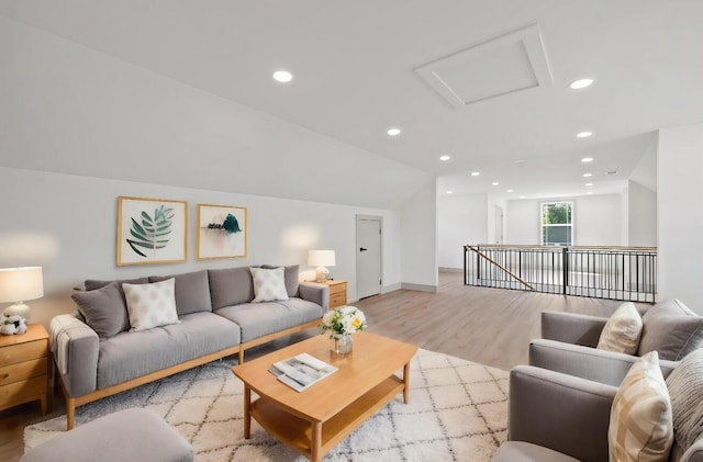 living room featuring vaulted ceiling and light wood-type flooring