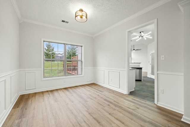 unfurnished room featuring light wood-type flooring, ornamental molding, and a textured ceiling