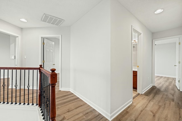 hall featuring a textured ceiling and light wood-type flooring