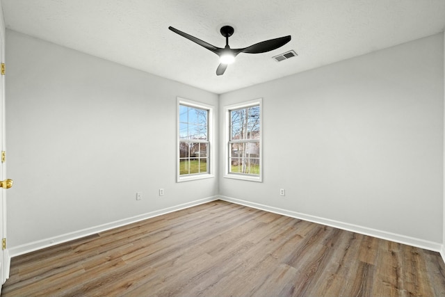 spare room with ceiling fan and light wood-type flooring