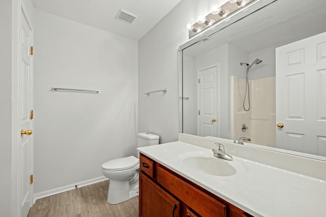 full bathroom featuring hardwood / wood-style floors, vanity, toilet, and shower / bathing tub combination