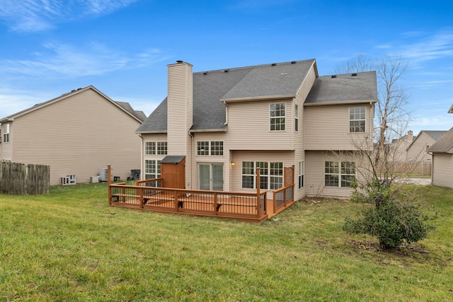 back of house featuring a lawn and a deck