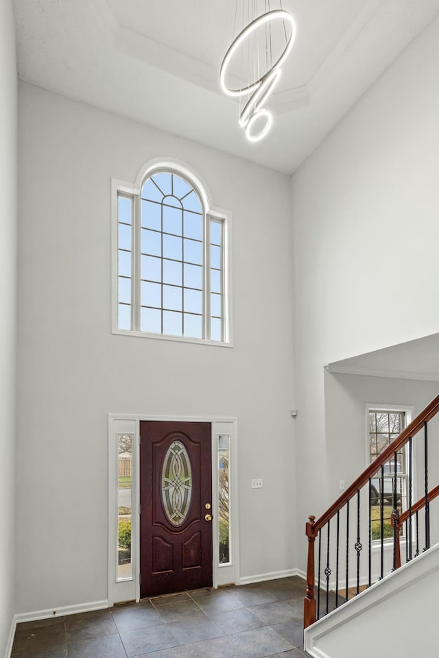 foyer entrance with a towering ceiling and a raised ceiling