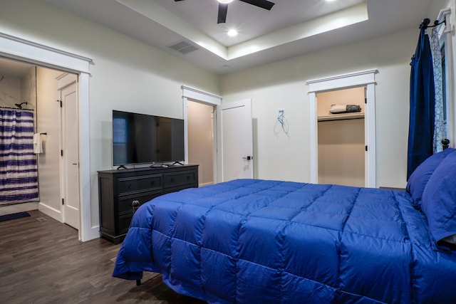 bedroom featuring a tray ceiling, ceiling fan, and dark wood-type flooring