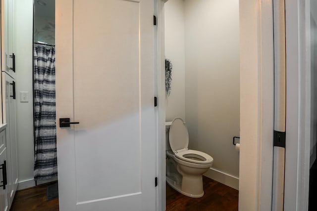 bathroom with hardwood / wood-style flooring and toilet