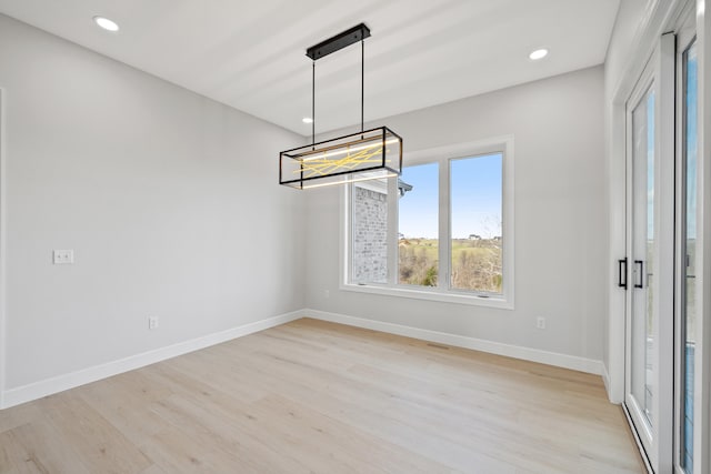 unfurnished dining area featuring light wood-type flooring