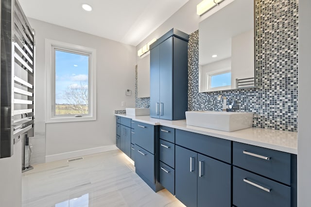 bathroom with tasteful backsplash, radiator, and vanity