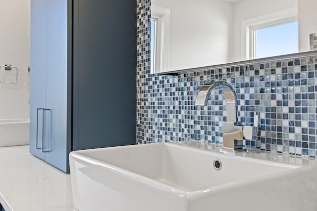 bathroom featuring decorative backsplash and sink