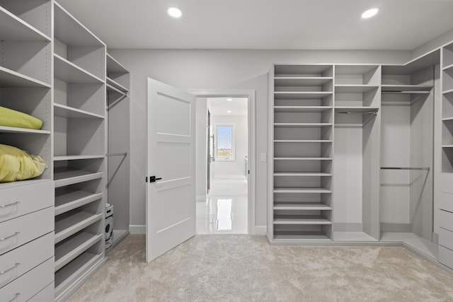 walk in closet with light colored carpet