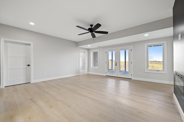 unfurnished living room with ceiling fan, french doors, and light hardwood / wood-style flooring